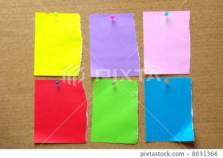 Notes paper splitting colored paper fastened with a thumbtack on the cork board 8031366