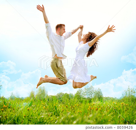 Happy Couple Outdoor. Jumping Family on Green Field 8039426