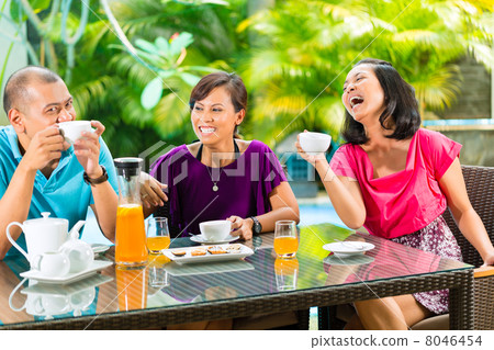 Asian friends having coffee on home porch Asian friends having coffee on home porch 8046454