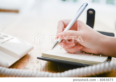 A woman writing in a notebook 8063673