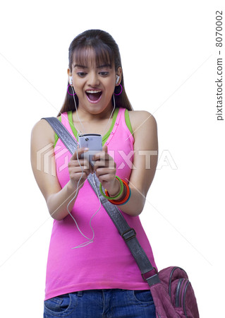 Surprised young college girl listening music over white background 8070002