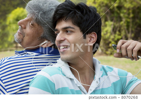Father and son listening to music 8070268