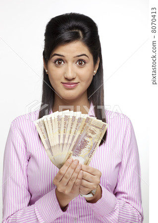 Portrait of a female executive with currency 8070413