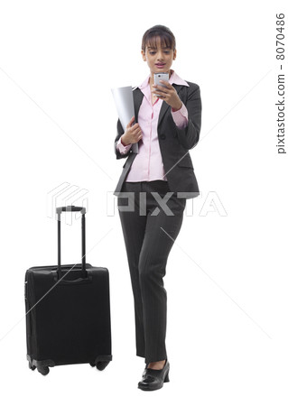 Happy young businesswoman with luggage reading text message 8070486