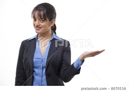 Portrait of confident young businesswoman presenting on white background Portrait of confident young businesswoman presenting on white background 8070516