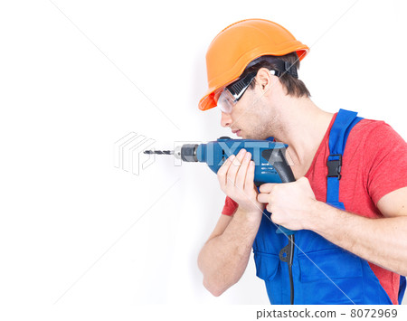 A man drilling a hole in the wall. 8072969
