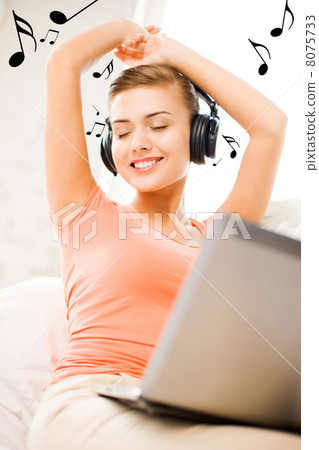 woman with headphones and laptop at home woman with headphones and laptop at home 8075733