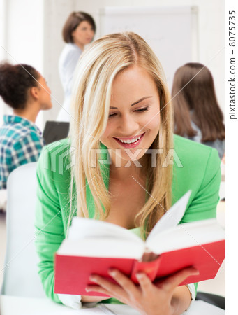 smiling student girl reading book at school smiling student girl reading book at school 8075735