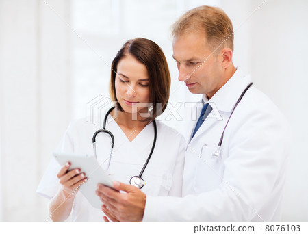 two doctors looking at tablet pc two doctors looking at tablet pc 8076103