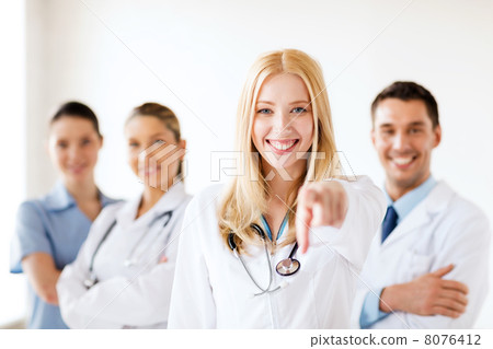 female doctor in front of medical group female doctor in front of medical group 8076412