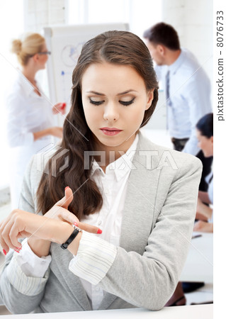 businesswoman looking at alarm clock businesswoman looking at alarm clock 8076733
