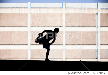 Male runner stretching before a run. Male runner stretching before a run. 8077047