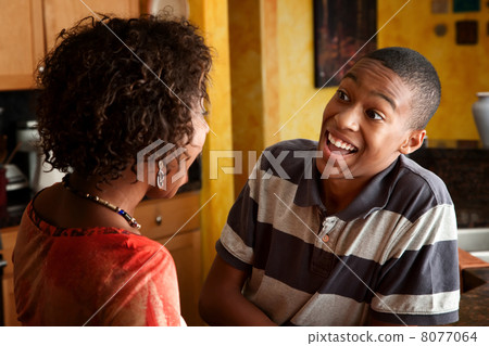 African-American woman and teen laugh in kitchen African-American woman and teen laugh in kitchen 8077064