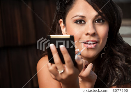 Beautiful Latina Woman with Compact Applying Lip Gloss Beautiful Latina Woman with Compact Applying Lip Gloss 8077390