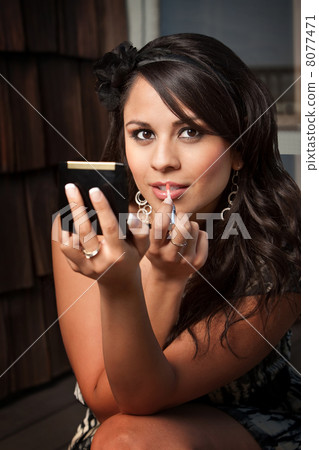 Beautiful Latina Woman with Compact Applying Lip Gloss Beautiful Latina Woman with Compact Applying Lip Gloss 8077471
