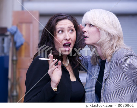 Women Gossip During a Smoking Break 8080901