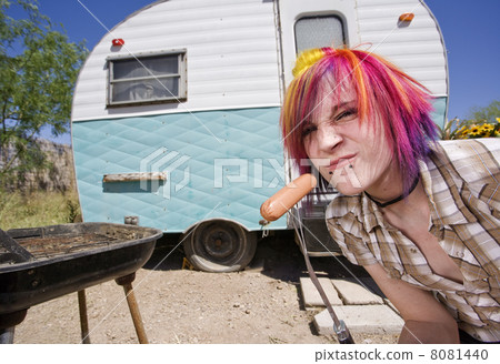 Girl in front of a trailer eating a hotdog Girl in front of a trailer eating a hotdog 8081440