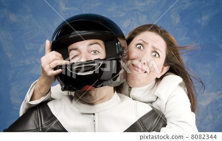 Man and fearful woman on a motorcycle Man and fearful woman on a motorcycle 8082344