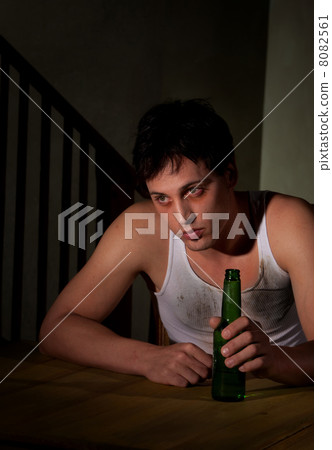 Depressed young man with beer bottle 8082561