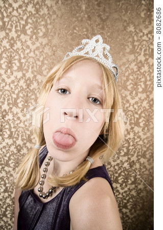 Pretty young girl with a tiara sticking her tongue out Pretty young girl with a tiara sticking her tongue out 8082686