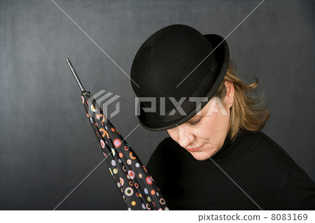 Woman in a bowler hat with umbrella 8083169