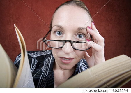 Peprlexed woman with big eyes reading a book 8083394