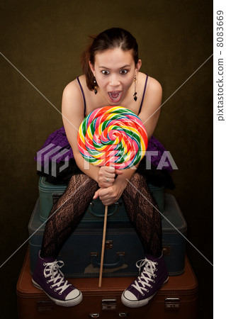 Pretty Girl in Purple on Green Background with Lollipop 8083669
