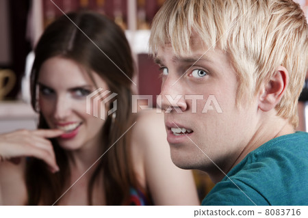 Woman flirting with uninterested male friend Woman flirting with uninterested male friend 8083716