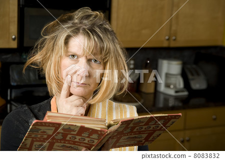 Harried woman with recipe book Harried woman with recipe book 8083832