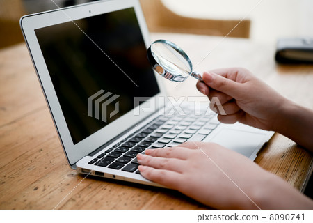 有放大鏡和婦女的手的便攜式計算機 8090741