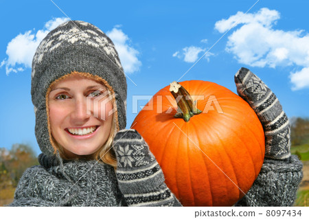 Young woman holding up a pumpkin Young woman holding up a pumpkin 8097434