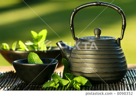 Black asian teapot with mint tea Black asian teapot with mint tea 8098352