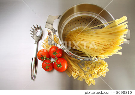 Overhead shot of pasta, tomatoes and pot on stainless steel 8098810