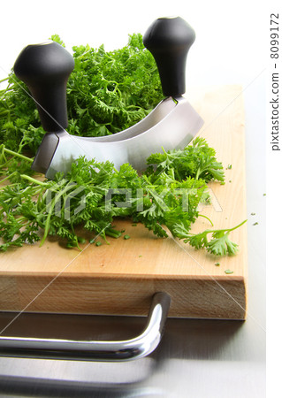 Freshly chopped parsley on wooden cutting 8099172