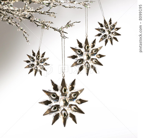 Silver snowflakes hanging against pale grey Silver snowflakes hanging against pale grey 8099195