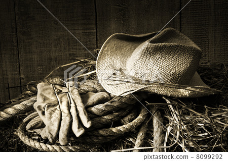 Straw hat with gloves on a bale of hay 8099292