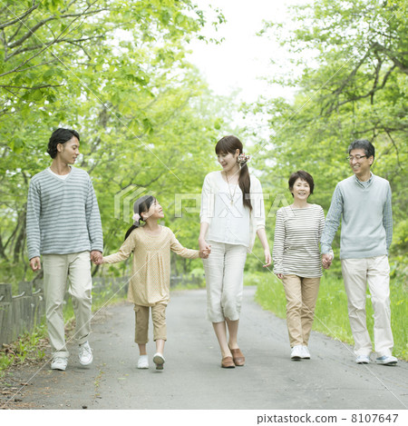 Three generations families holding hands in fresh green 8107647