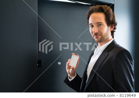 Businessman with key card for room door in hotel 8119649