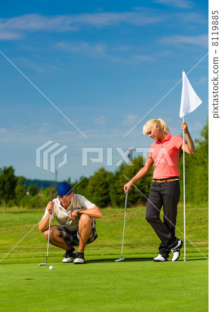 圖庫照片: young sportive couple playing golf on a course