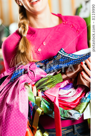 Woman is buying Tracht or dirndl in a shop Woman is buying Tracht or dirndl in a shop 8119990