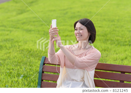 A woman listening to music on a smartphone 8121245
