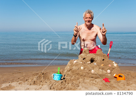 Elderly man with sand castle Elderly man with sand castle 8134790