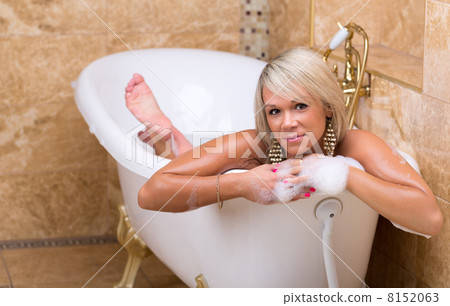 Beautiful tanned girl is taking a luxurious bath 8152063