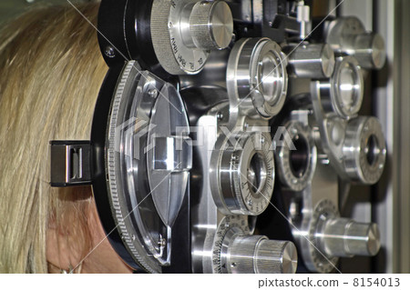 Female patient at ophthalmologist in phoropter 8154013