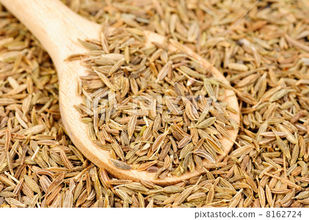 Cumin seeds macro and wooden spoon as background 8162724