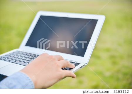 在戶外草坪上操作筆記型電腦的雙手 在戶外草坪上操作筆記型電腦的雙手 8165112