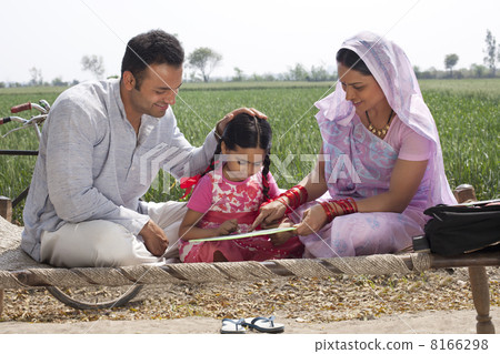 Indian mother and father helping daughter with her homework 8166298