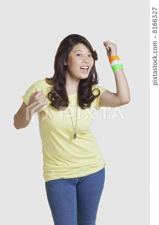 Portrait of happy young woman in casuals wearing Indian tricolor bangles over white background Portrait of happy young woman in casuals wearing Indian tricolor bangles over white background 8166327