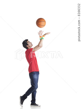 Side view of young boy in casuals tossing basketball over white background 8166332