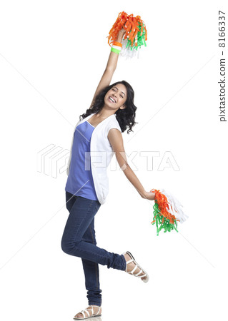 Full length of happy young woman cheering with Indian tricolor pom poms over white background 8166337